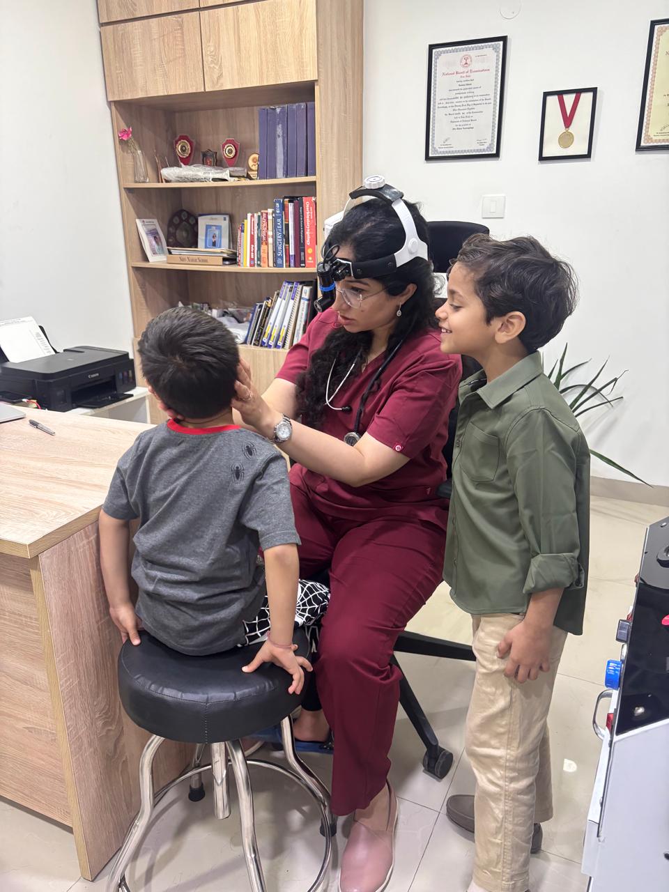 Dr. Aashima Chopra examining children during a pediatric ENT consultation